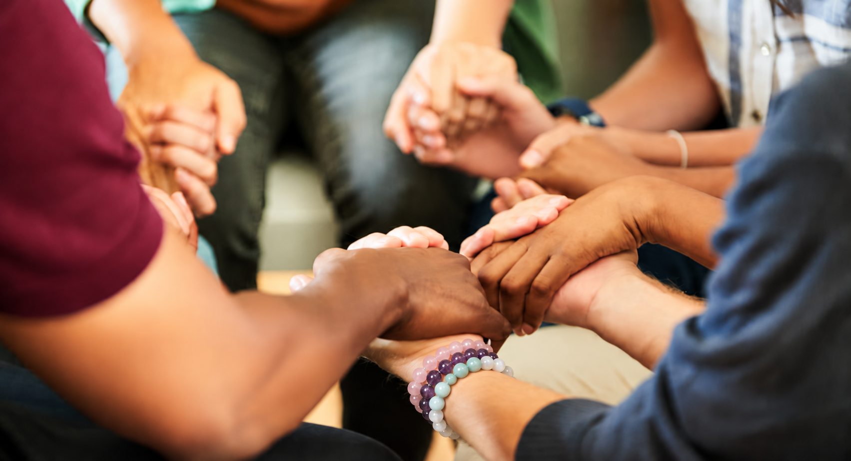 People sitting in a circle holding hands in support