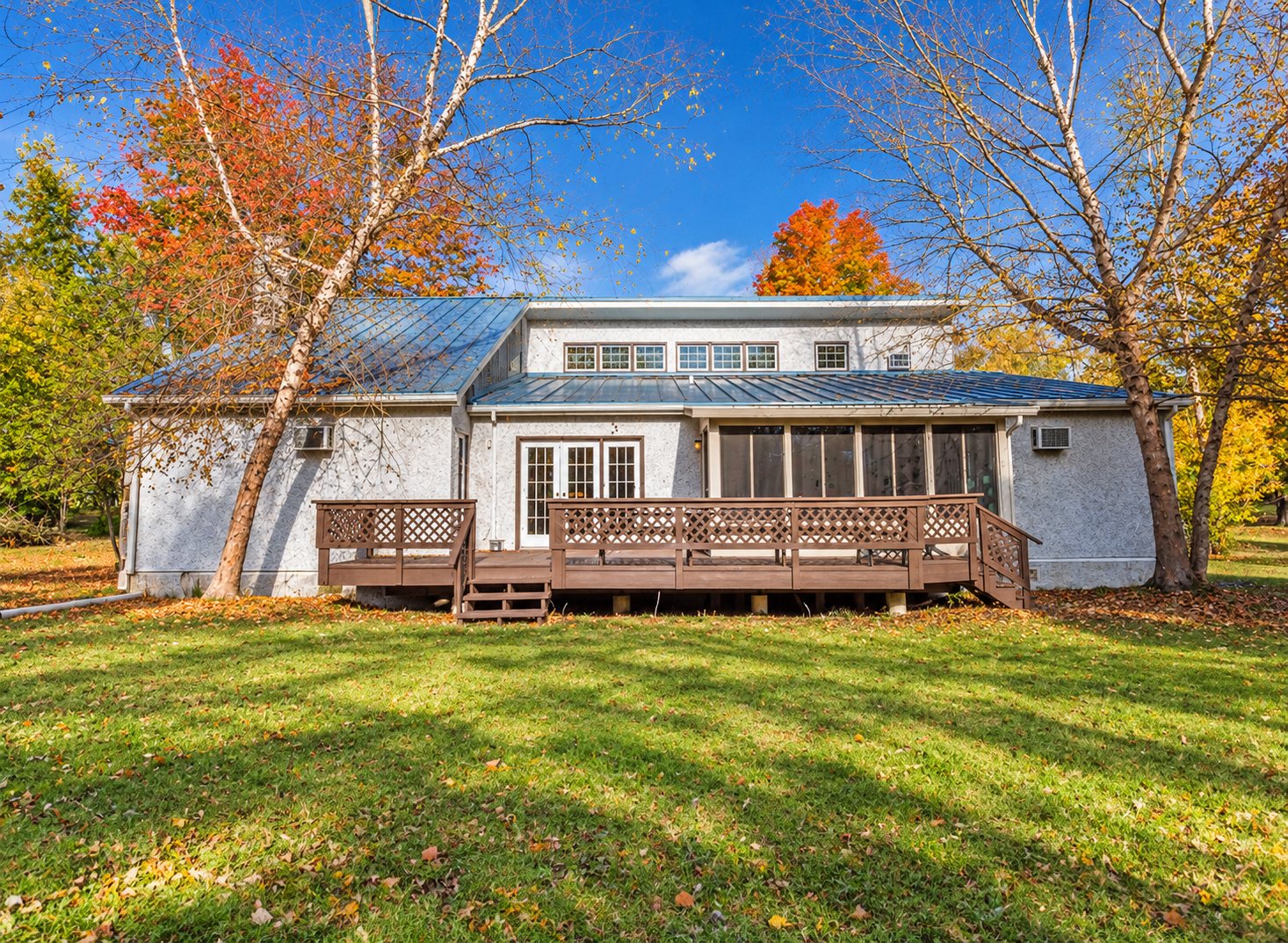 Back of the Sunlight men's house in Hatfield with its deck and autumn trees